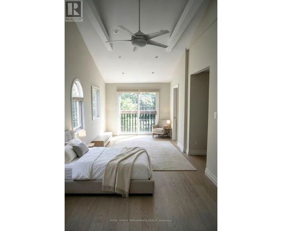 A bedroom with a large bed and a ceiling fan.