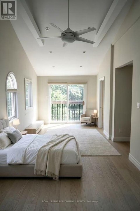 A bedroom with a large bed and a ceiling fan.