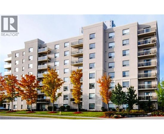 A large apartment building with balconies and trees in front.
