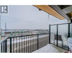 A balcony with a view of a parking lot and buildings.