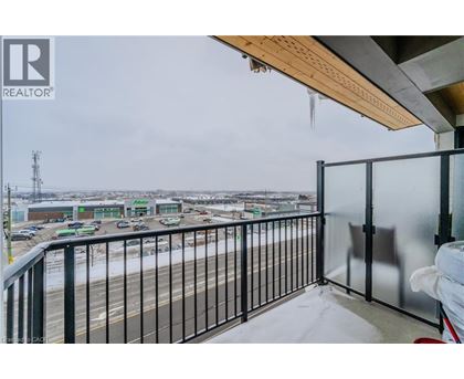 A balcony with a view of a parking lot and buildings.