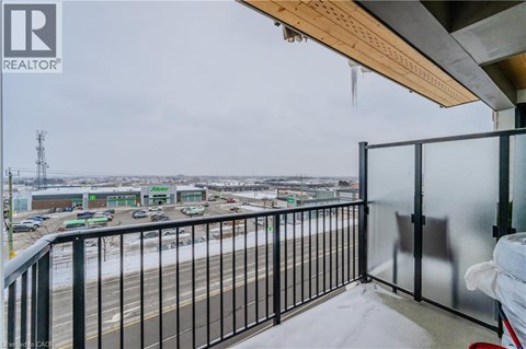 A balcony with a view of a parking lot and buildings.