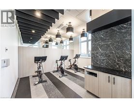 A gym with a row of stationary bikes and a black and white checkered floor.