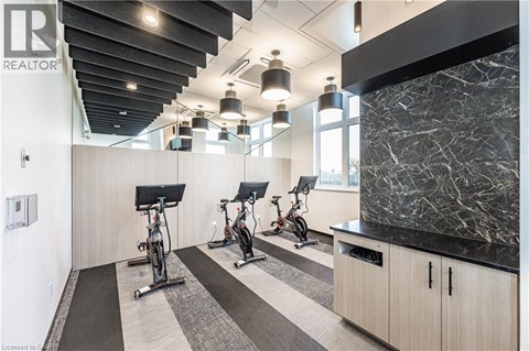 A gym with a row of stationary bikes and a black and white checkered floor.
