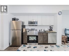 A modern kitchen with a stainless steel refrigerator and wooden cabinets.