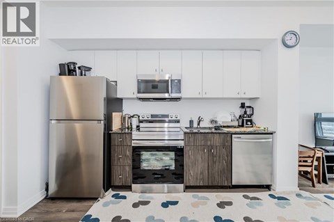 A modern kitchen with a stainless steel refrigerator and wooden cabinets.