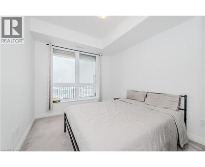 A bedroom with a large bed and a window with a view.