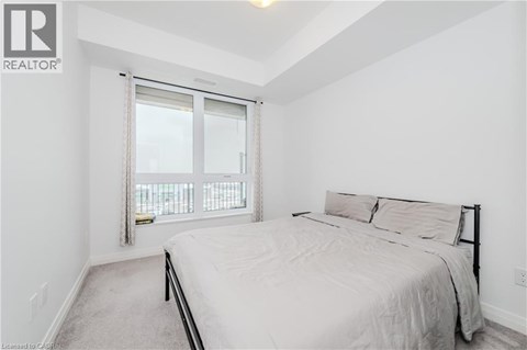 A bedroom with a large bed and a window with a view.