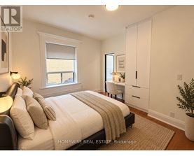 A bedroom with a large bed and a desk with a chair.