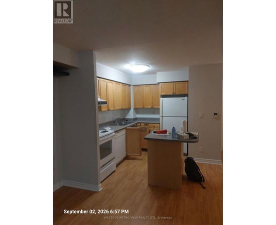 A kitchen with wooden cabinets and a white refrigerator.