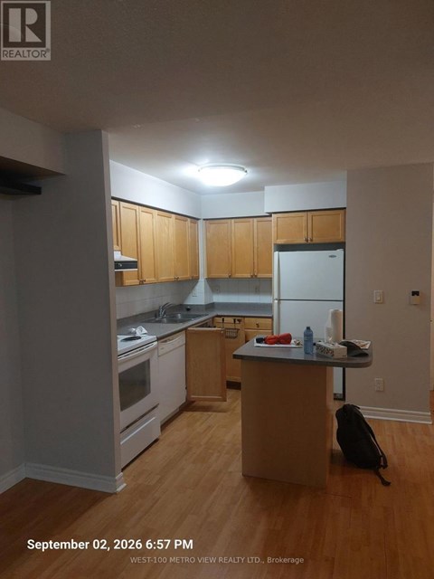 A kitchen with wooden cabinets and a white refrigerator.