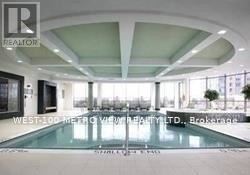 A large, modern indoor swimming pool with a glass bottom.