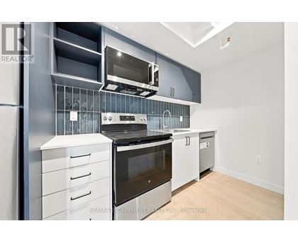 A modern kitchen with stainless steel appliances and white cabinets.