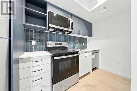 A modern kitchen with stainless steel appliances and white cabinets.