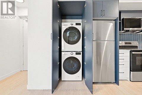 A modern kitchen with a washer and dryer built into the cabinetry.