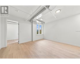 A room with a door and a window with a view of trees outside.