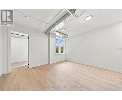 A room with a door and a window with a view of trees outside.