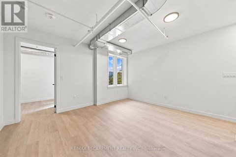 A room with a door and a window with a view of trees outside.