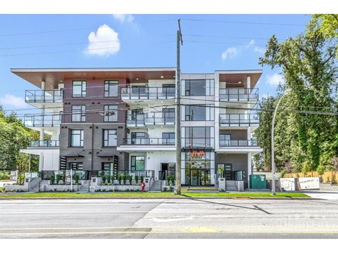 A modern multi-story building with a flat roof and balconies.