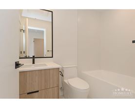 A white bathroom with a toilet, sink, and bathtub.