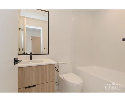A white bathroom with a toilet, sink, and bathtub.