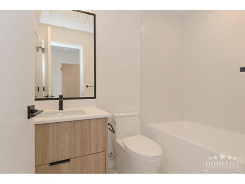 A white bathroom with a toilet, sink, and bathtub.