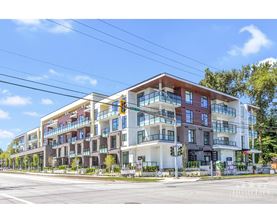 A modern multi-story apartment building with balconies and large windows.