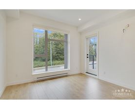 A room with a large window and wooden flooring.