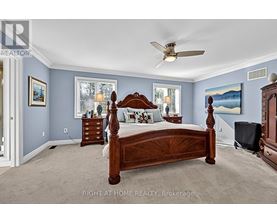 A bedroom with a large bed and a ceiling fan.