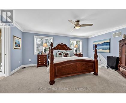 A bedroom with a large bed and a ceiling fan.