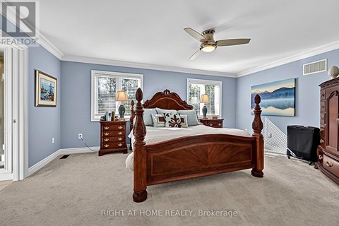 A bedroom with a large bed and a ceiling fan.