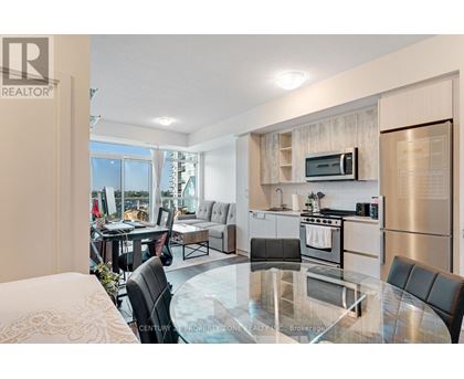 A modern kitchen with a glass table and stainless steel appliances.