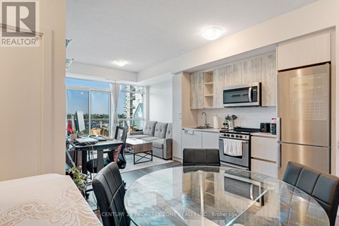 A modern kitchen with a glass table and stainless steel appliances.