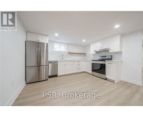 A kitchen with white cabinets and a stainless steel refrigerator.