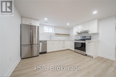 A kitchen with white cabinets and a stainless steel refrigerator.