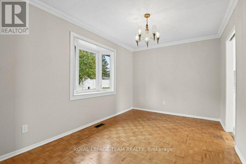 A room with a wooden floor and a chandelier.