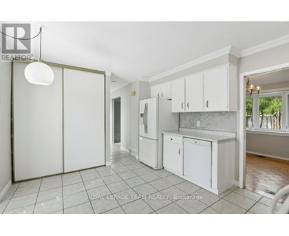 A kitchen with white cabinets and a tile floor.