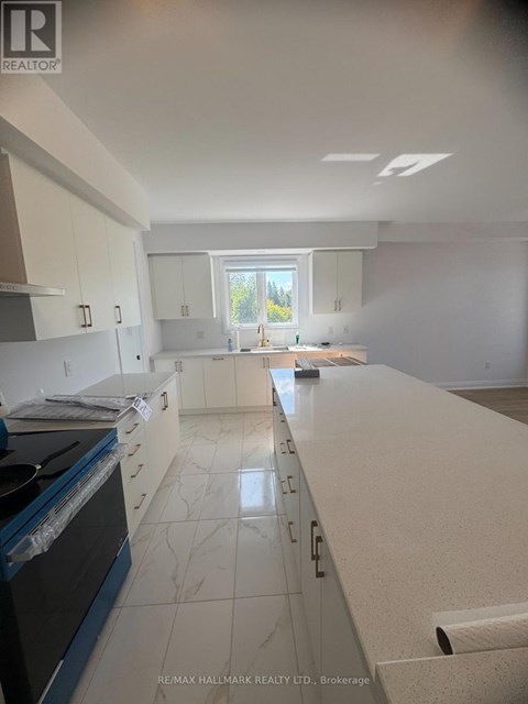 A kitchen with white cabinets and a black stove top oven.
