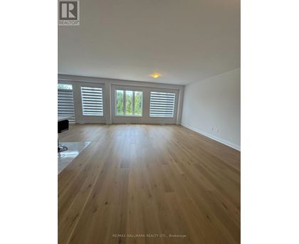 A spacious room with wooden flooring and white walls.