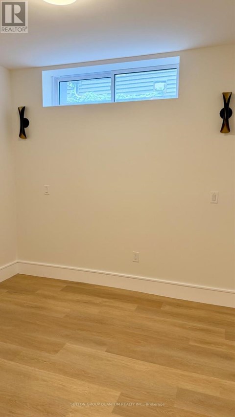 A room with wooden flooring and a window with blinds.