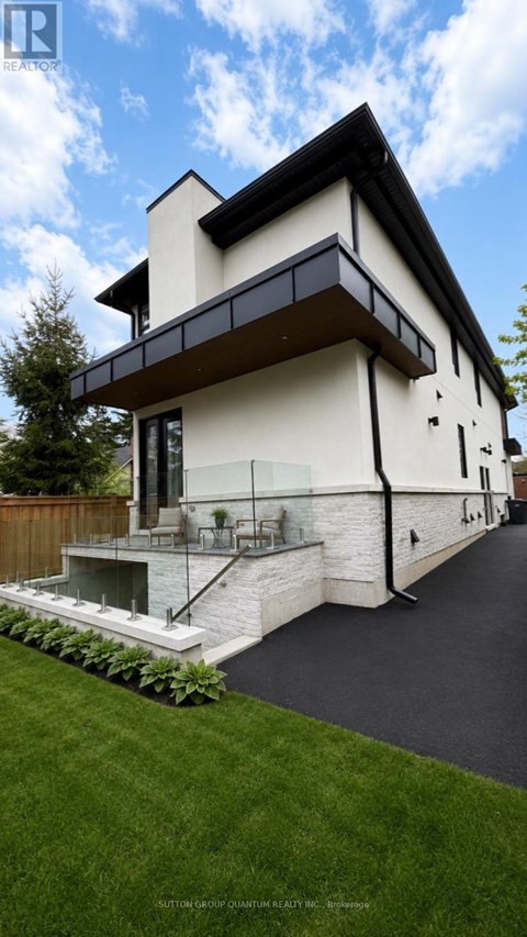 A modern house with a white exterior and a black roof.