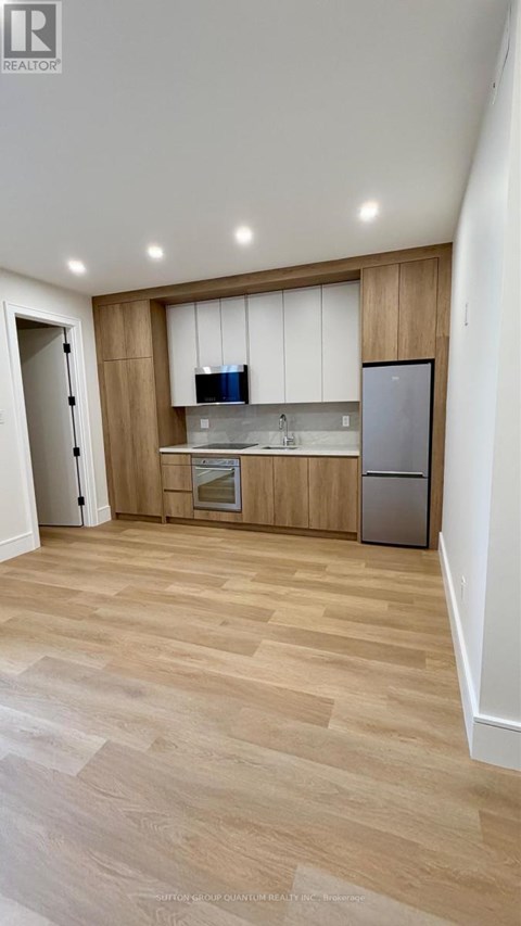 A kitchen with wooden cabinets and a refrigerator.