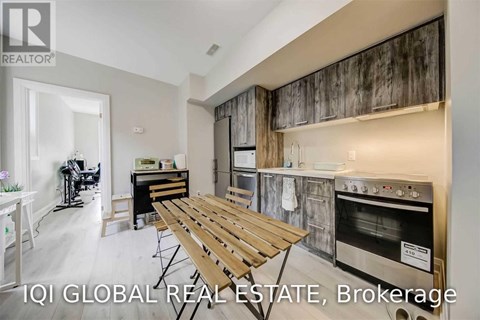 A modern kitchen with a wooden table and stainless steel appliances.