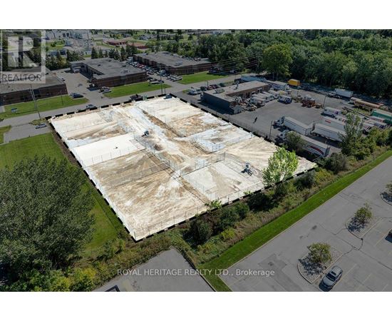 An aerial view of a large, empty parking lot with a building in the background.