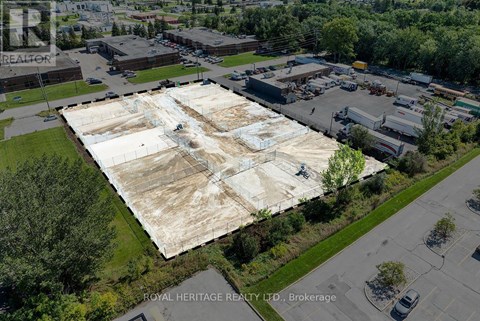 An aerial view of a large, empty parking lot with a building in the background.