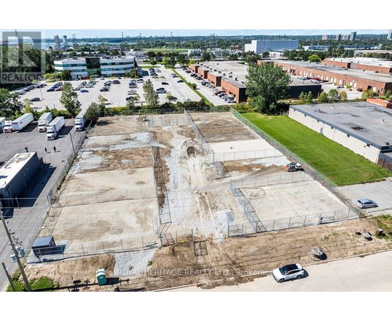An aerial view of a large, empty parking lot with a building in the background.