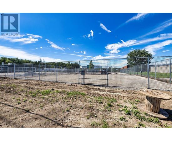 A construction site with a fence and a wooden barrel on the ground.