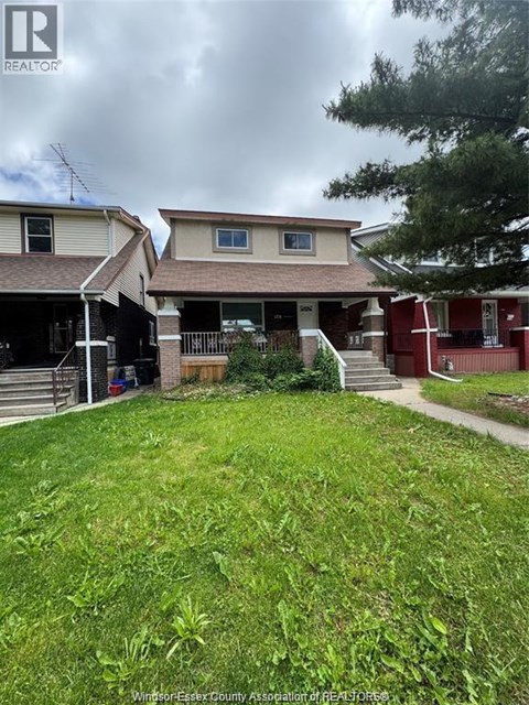A grassy yard in front of a house with a sign that says REALTOR.