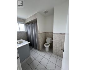 A bathroom with a toilet, sink, and shower curtain.