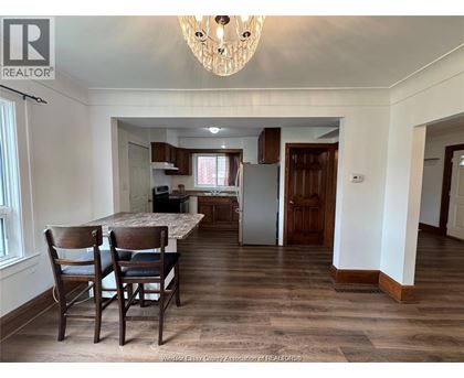 A dining room with a table and chairs.